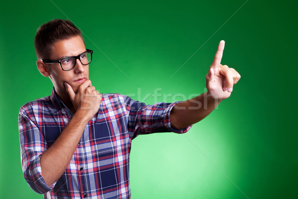 Young casual man pensively selecting something Stock photo © feedough