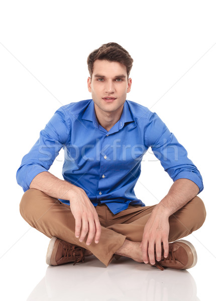 élégant jeune homme séance jambes croisées isolé sourire [[stock_photo]] © feedough