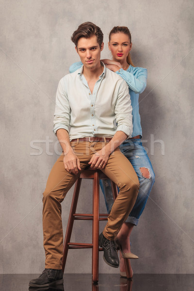 man in studio seated while girl in the back rests Stock photo © feedough
