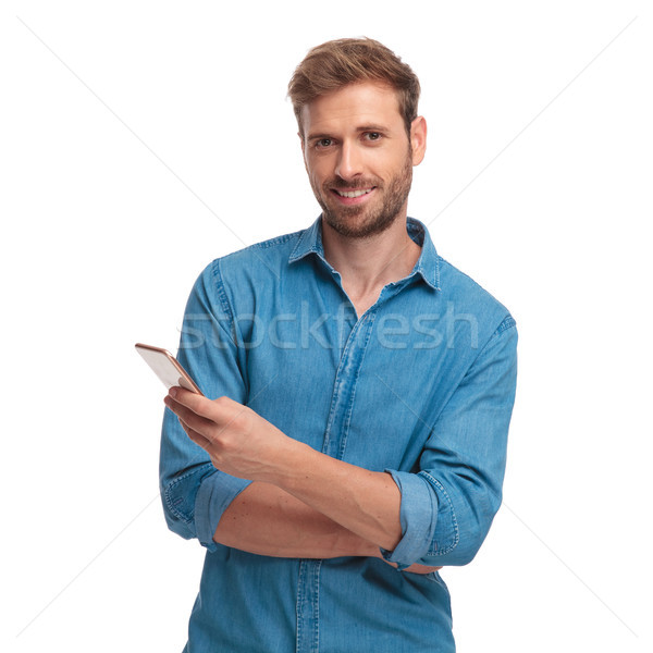 young casual student writes sms message on his mobile phone  Stock photo © feedough