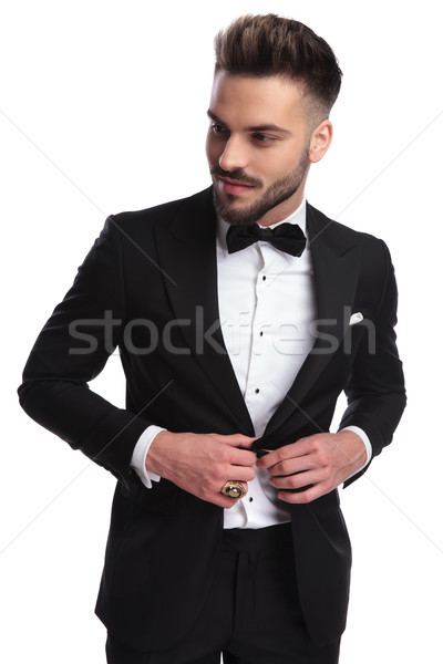 smiling young man in tuxedo opening his coat Stock photo © feedough