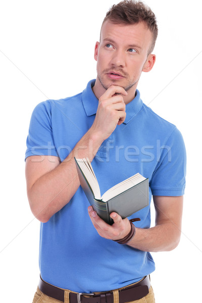 pensive young casual man holds book Stock photo © feedough