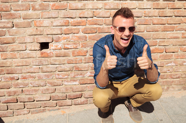 casual man thumbs up by wall Stock photo © feedough