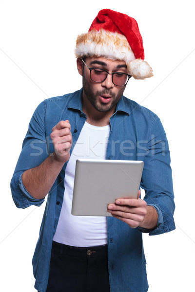 man in santa hat is reading something surprising on pad Stock photo © feedough