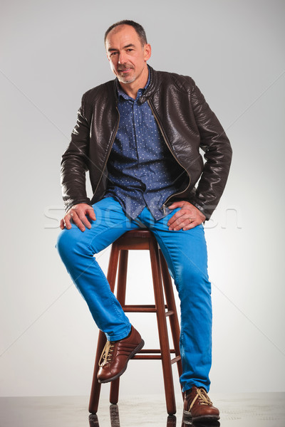 full body picture of seated old man in leather jacket Stock photo © feedough