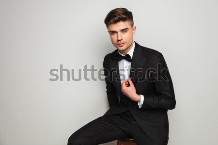 elegant man holding tuxedo's collar and looks to side Stock photo © feedough