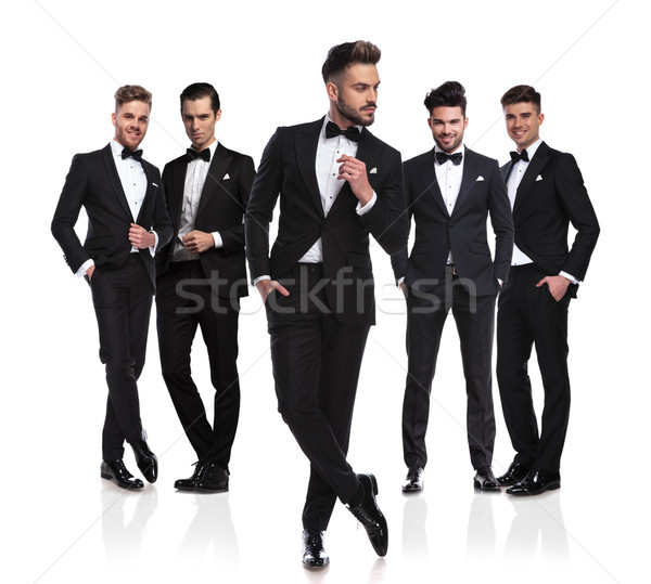 five grooms in black  tuxedoes with pensive leader in front Stock photo © feedough