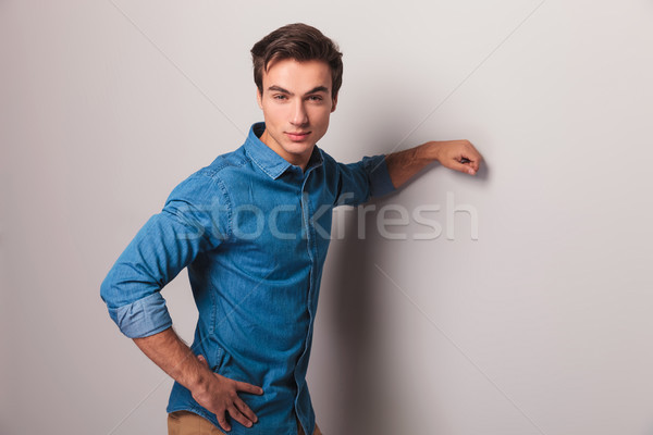 casual man leaning elbow on grey wall  Stock photo © feedough