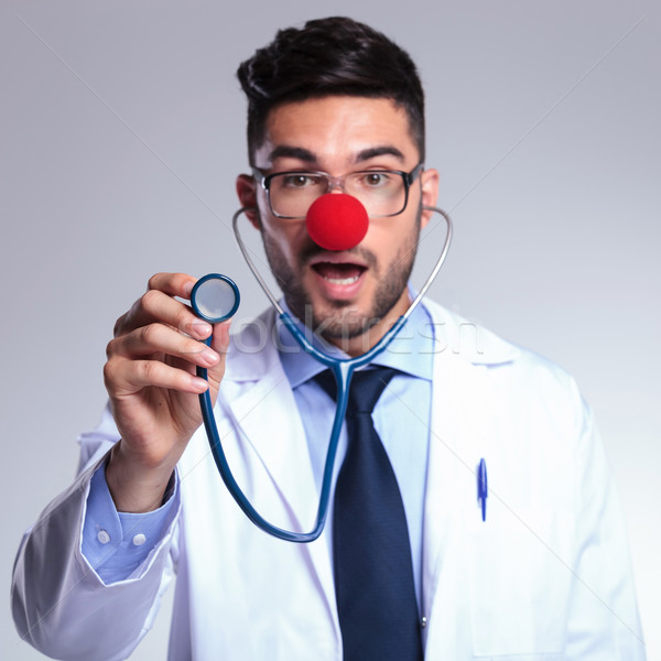 young doctor listens to you at stethoscope with red nose Stock photo © feedough