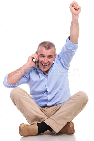 casual old man sits and cheers while on phone Stock photo © feedough