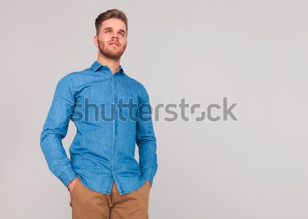 Stock photo: side view of a fashion man in jeans clothes smiling