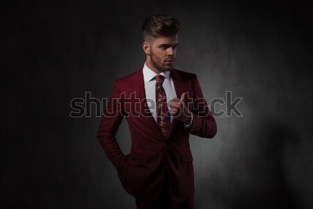 relaxed handsome man buttoning his red suit looks to side Stock photo © feedough