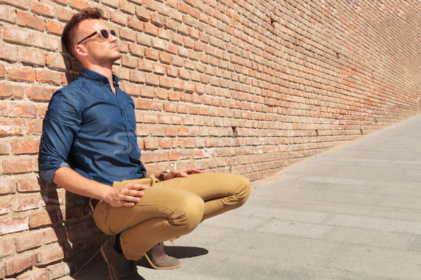casual man sits by wall Stock photo © feedough