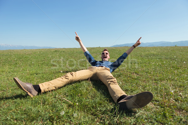 casual man laying in the grass and cheering Stock photo © feedough