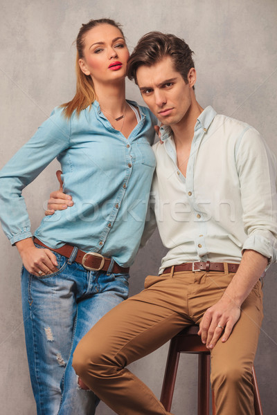 man seated, pulling his girlfriend closer while she stands Stock photo © feedough