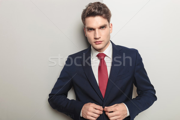 handsome young business man closing his jacket  Stock photo © feedough
