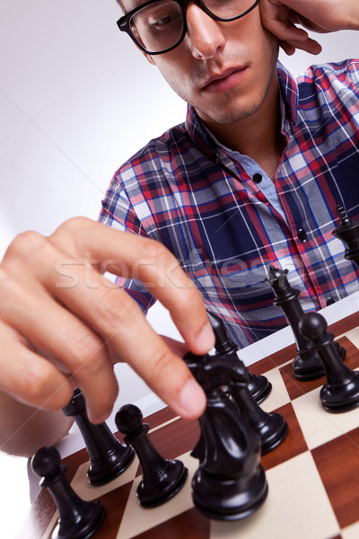 A young casual man moving his chess piece  Stock photo © feedough