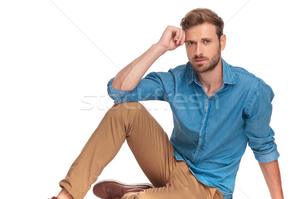 Stock photo: casual young man sitting on the floor and thinks 