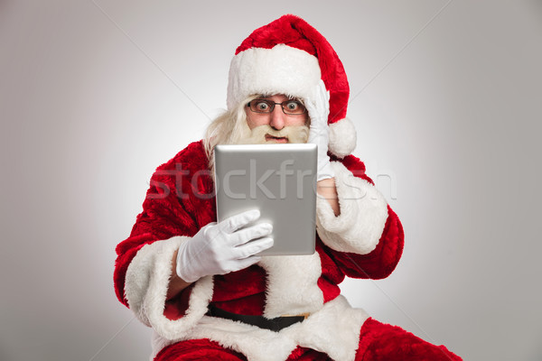 santa claus is reading something shocking on his tablet  Stock photo © feedough