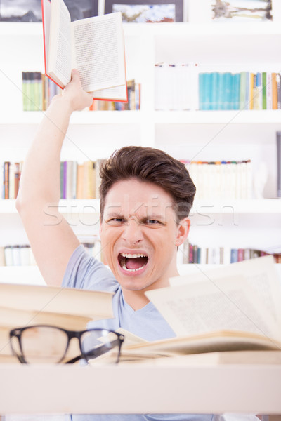 angry student with expression surrounded by books  throwing a bo Stock photo © feelphotoart