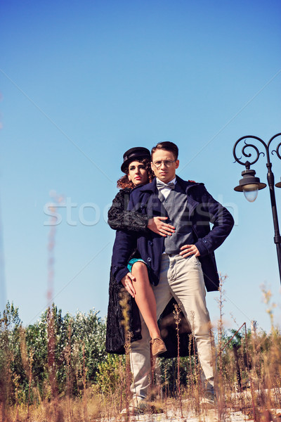 Two fashion people in vintage style posing in below shot Stock photo © feelphotoart