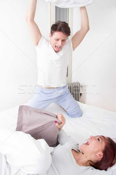 boy in pajamas hitting girl with pillow Stock photo © feelphotoart