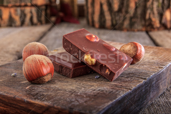 Chocolate with hazelnuts on wooden board Stock photo © feelphotoart
