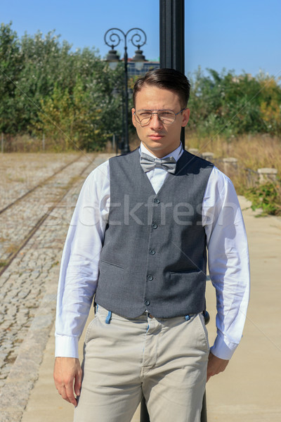 man in shirt and vest with bow tie and glasses, standing leaning Stock photo © feelphotoart