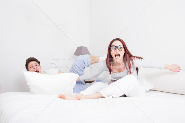 couple in pillow fight with face expression Stock photo © feelphotoart