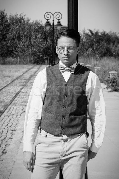 Man in vest standing by the railway leaning against lamppost Stock photo © feelphotoart