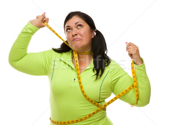 Frustrated Hispanic Woman Tied Up With Tape Measure Stock photo © feverpitch