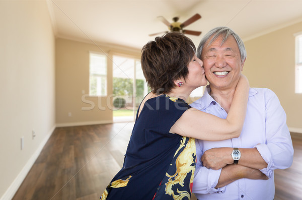 Happy Senior Chinese Couple Kissing Inside Empty Room Of New Hou Stock photo © feverpitch