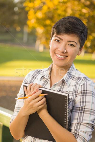 Portrait of a Pretty Mixed Race Female Student Holding Books Stock photo © feverpitch