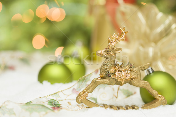 Golden Christmas Reindeer Ornament Among Snow, Bulbs and Ribbon Stock photo © feverpitch
