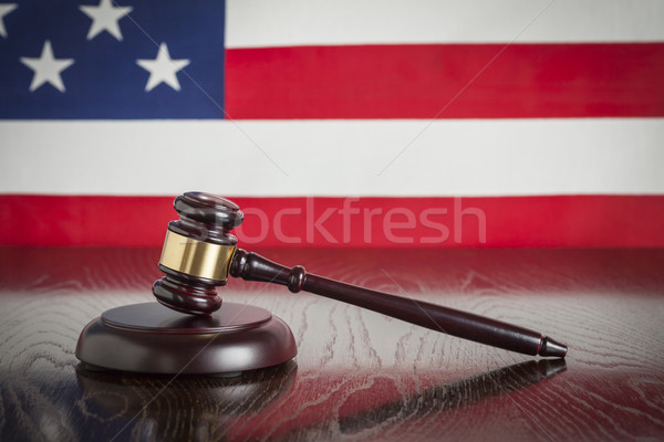 Wooden Gavel Resting on Flag Reflecting Table Stock photo © feverpitch