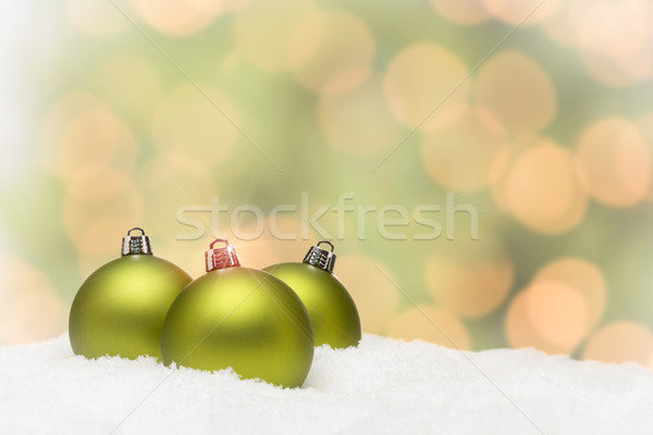 Green Christmas Ornaments on Snow Over an Abstract Background Stock photo © feverpitch
