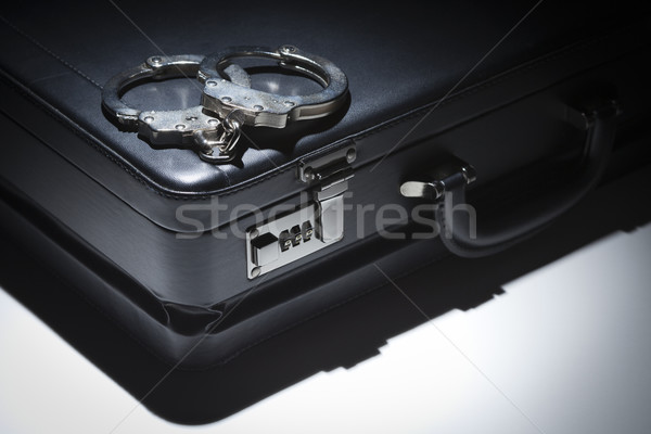 Pair of Handcuffs and Briefcase Under Spot Light Stock photo © feverpitch