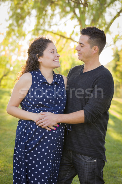 Stock photo: Hispanic Man With His Pregnant Wife Outdoors At the Park