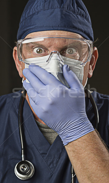 Stock photo: Stunned Doctor or Nurse with Protective Wear and Stethoscope