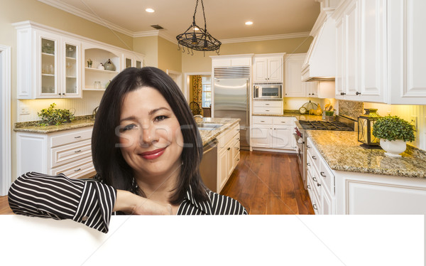 Stock photo: Hispanic Woman Leaning Against White In Custom Kitchen Interior