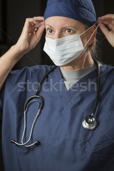 Female Doctor or Nurse Putting on Protective Face Mask Stock photo © feverpitch