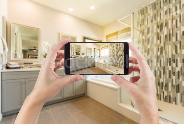 Master Bathroom Interior and Hands Holding Smart Phone with Phot Stock photo © feverpitch