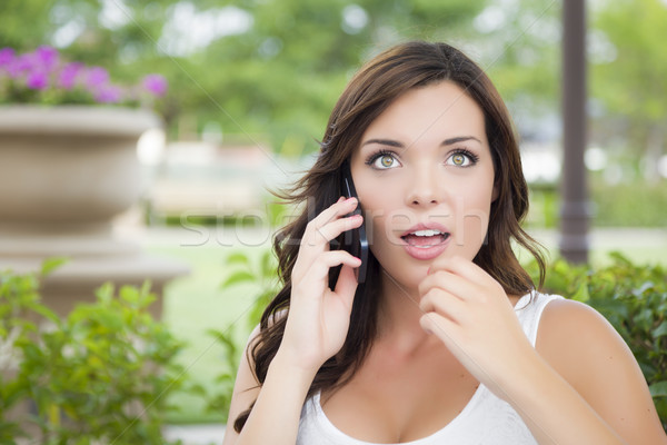 Stunned Young Adult Female Talking on Cell Phone Outdoors Stock photo © feverpitch