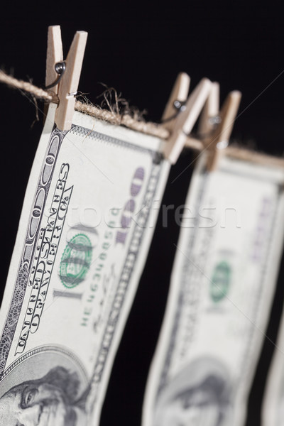 Hundred Dollar Bills Hanging From Clothesline on Dark Background Stock photo © feverpitch