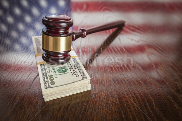 Stock photo: Wooden Gavel Resting on Money with American Flag Reflection