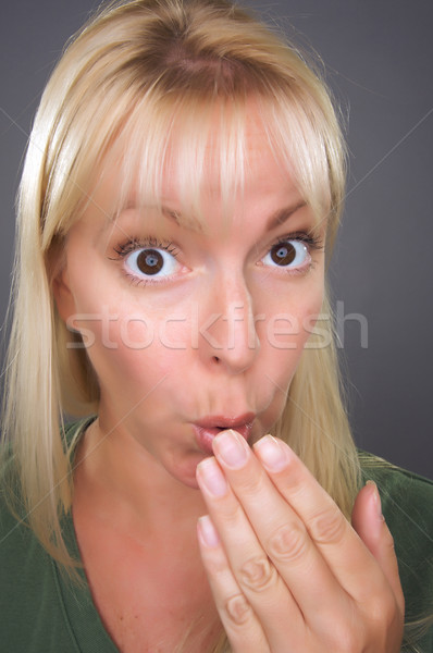 Geschokt blond vrouw hand mond grijs Stockfoto © feverpitch
