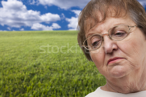 Melancholia starszy kobieta pole trawy za chmury Zdjęcia stock © feverpitch