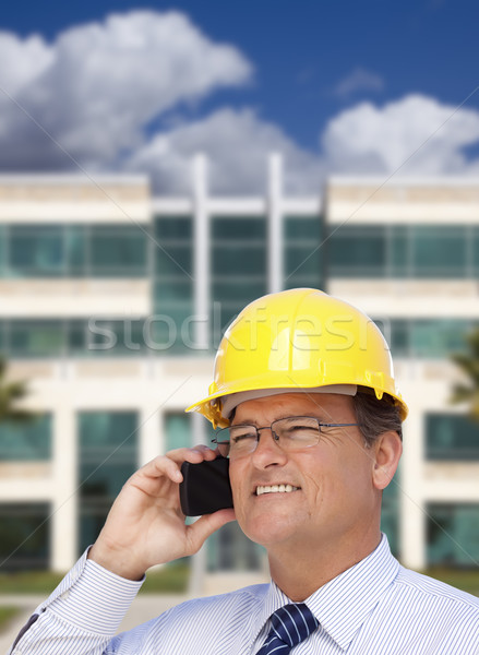 Contractor in Hardhat Talks on Phone In Front of Building Stock photo © feverpitch