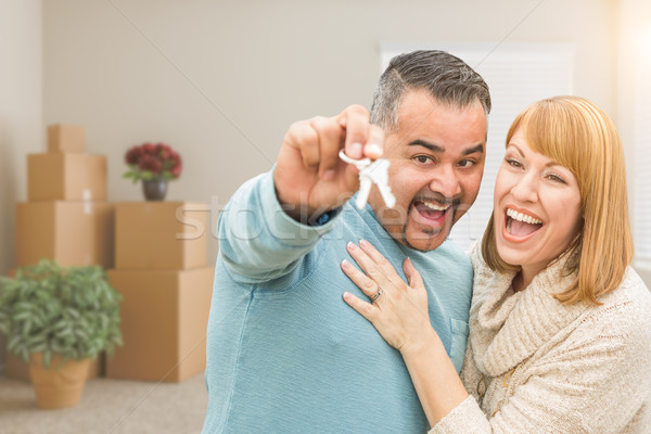 Couple Holding House Keys Inside Empty Room with Moving Boxes Stock photo © feverpitch