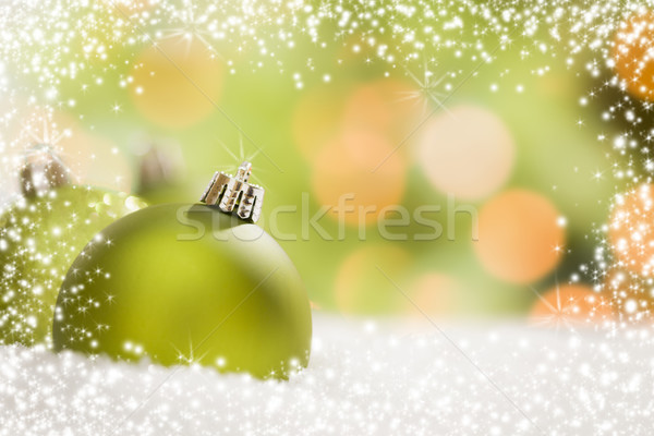 Stock photo: Green Christmas Ornaments on Snow Over an Abstract Background